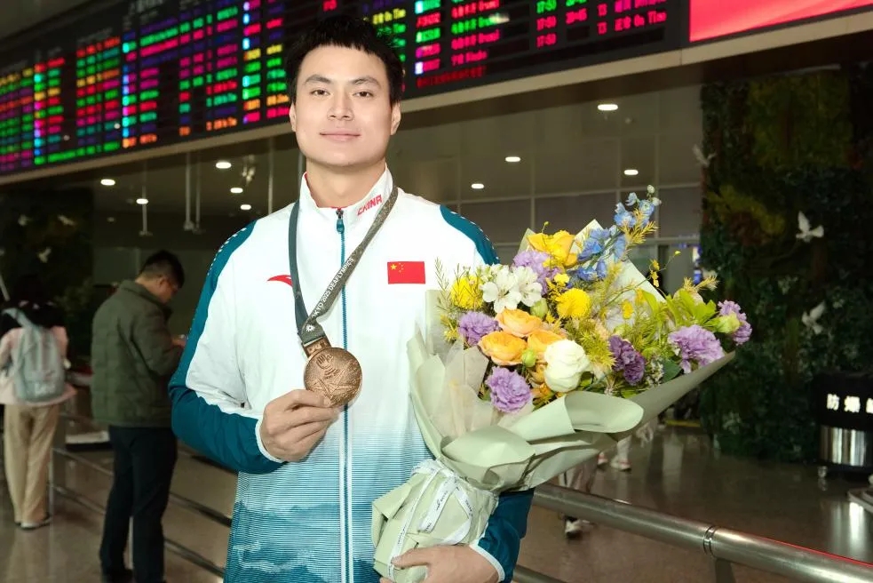 胡太军手握铜牌和鲜花